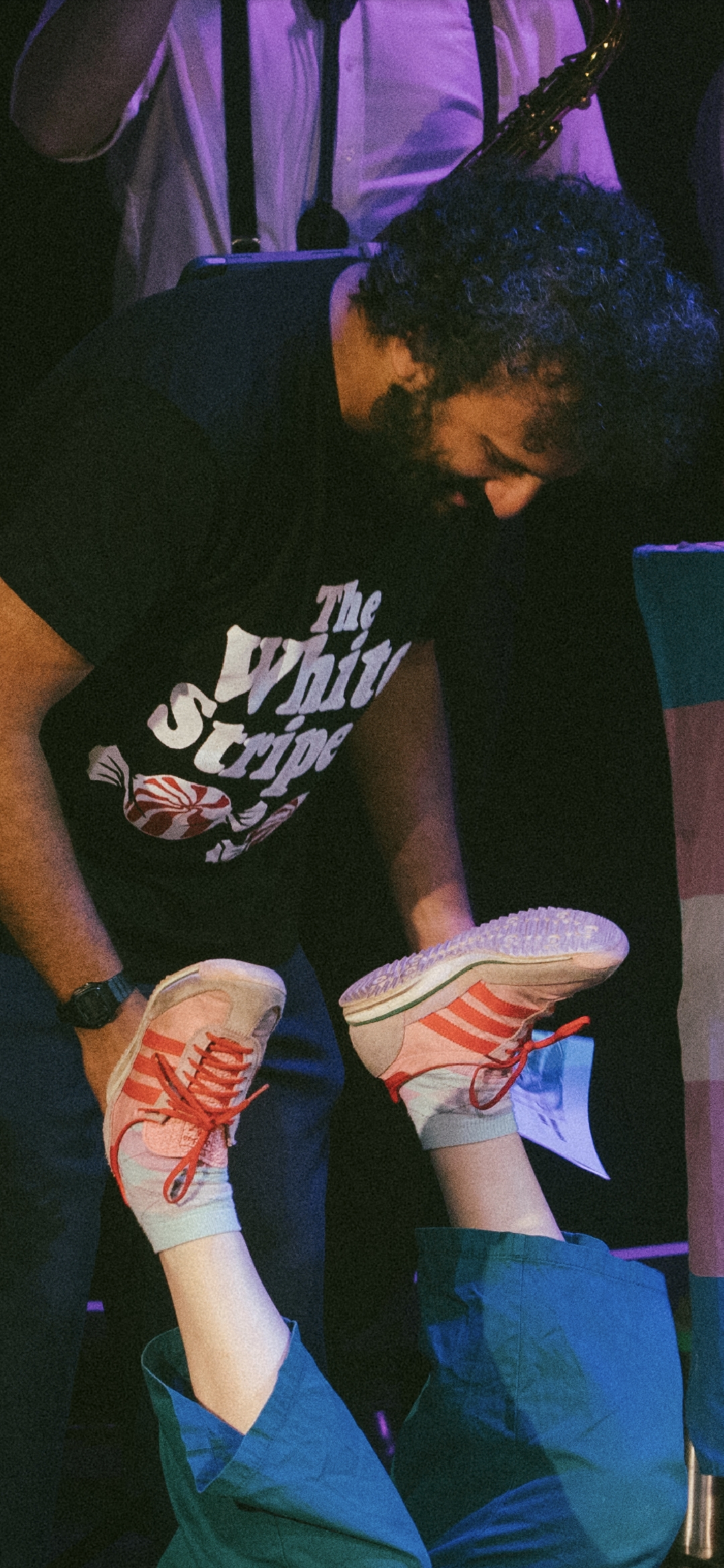 Photo of Nish Kumar, a british asian comedian, looking in shocked disbelief at the pair of legs beneath him. He is indeed holding my zine in his hand, although it is partially obscured by the legs.